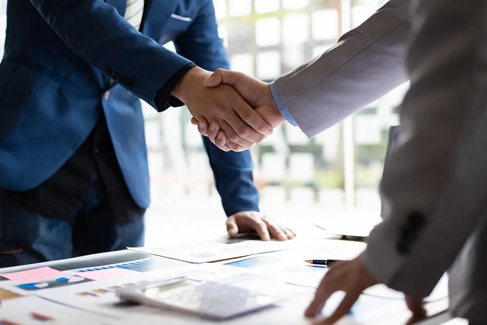 Businessmen shaking hands over a contract.