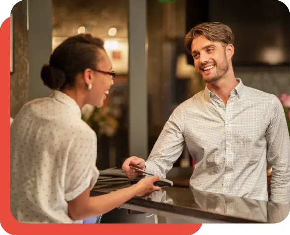 Woman paying man at a counter.