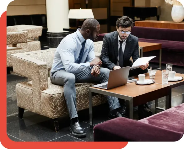 Two businessmen discussing business on a sofa.