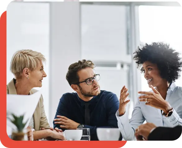 Three people talking at a business meeting.