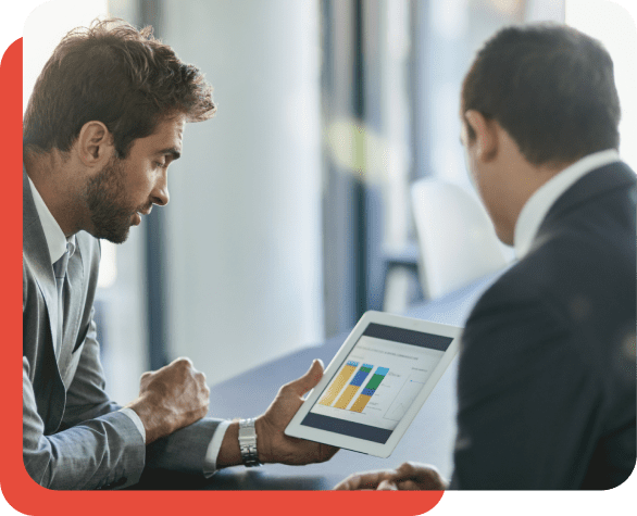 Two businessmen reviewing data on a tablet.